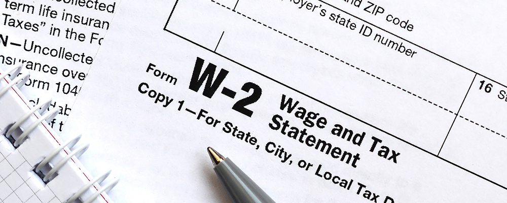 Pen and notebook on the tax form W-2 Wage and Tax Statement